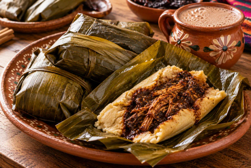 Tamales oaxaqueños de mole negro en hoja de plátano