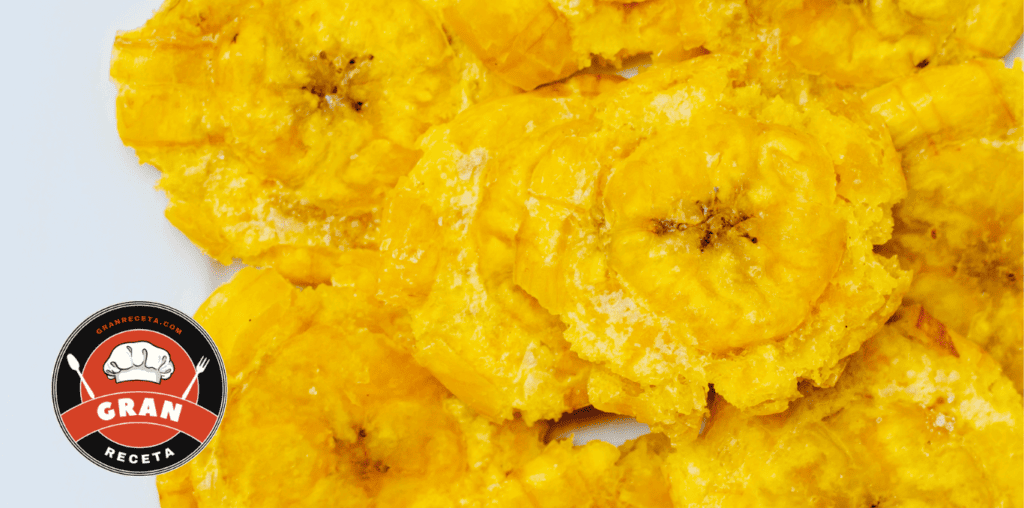 Proceso de aplastado de plátano verde entre plásticos para hacer patacones