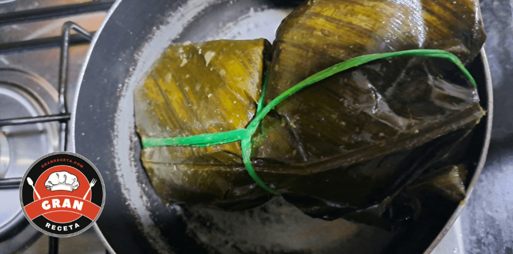 Proceso de armado de tamales de cerdo sobre hoja de plátano
